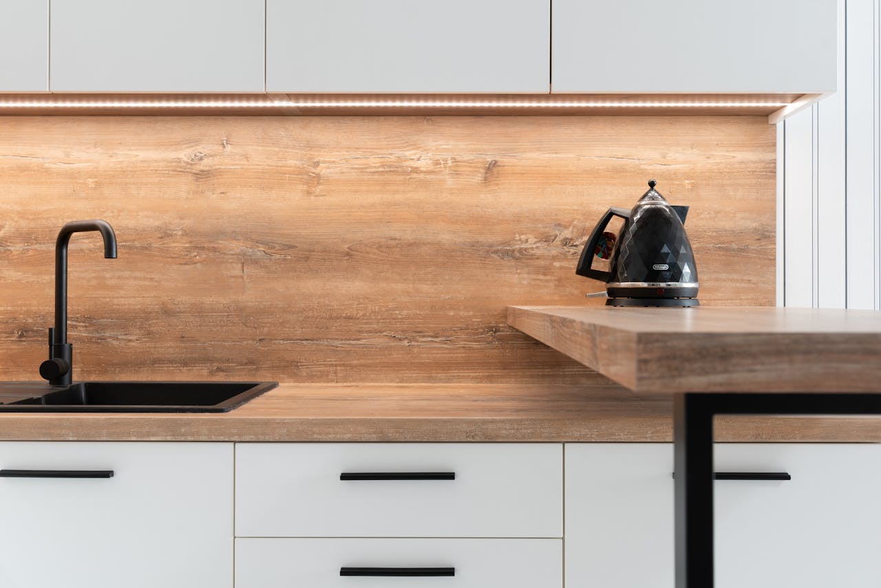 Kettle placed on wooden counter of minimalist kitchen